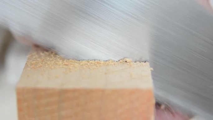 钢锯，钢锯切割木梁特写。