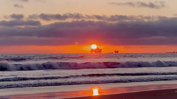 从亨廷顿海滩 (Huntington Beach) 可以欣赏到海上石油钻机平台上的壮丽日落