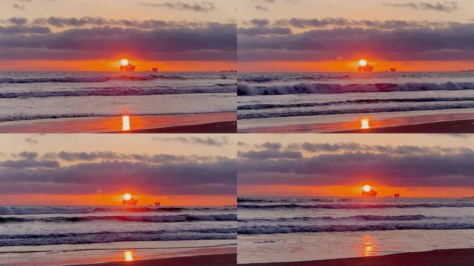 从亨廷顿海滩 (Huntington Beach) 可以欣赏到海上石油钻机平台上的壮丽日落