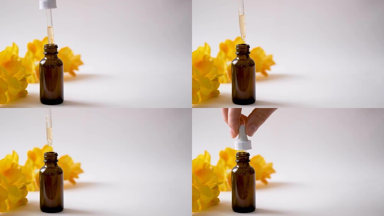 深色玻璃瓶，含透明质酸或化妆品精华液和黄色春花。