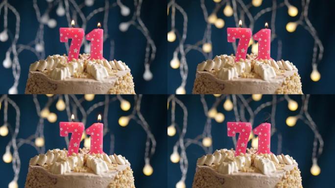 蓝色背景上有71号粉色蜡烛的生日蛋糕。蜡烛吹灭了。慢动作和特写视图