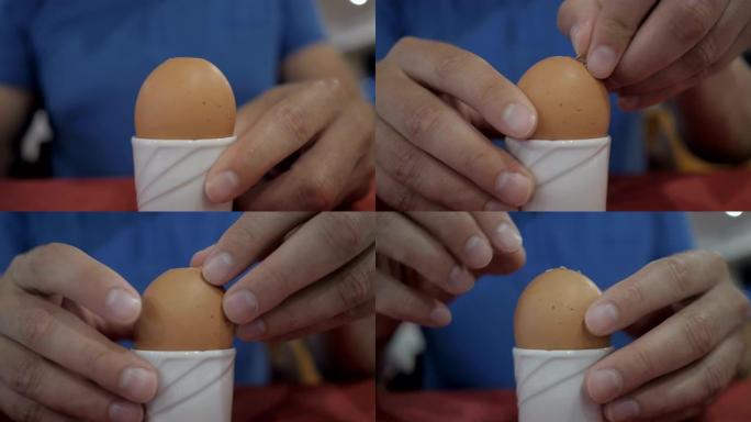 男性手在剥鸡蛋 ..慢动作。男人打扫干净，吃一个煮鸡蛋。特写。放在架子上煮鸡蛋。4K UHD