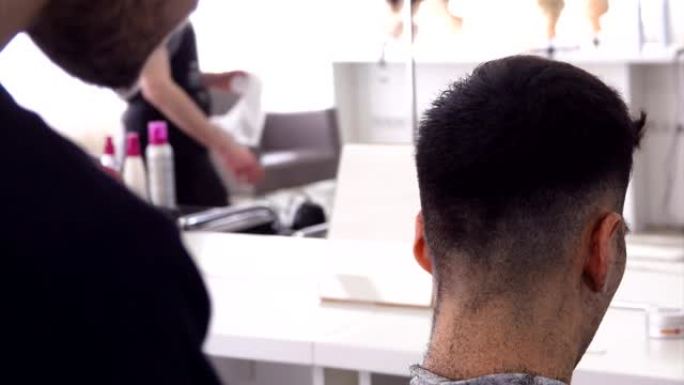 美发师向黑发客户进行机器理发的特写镜头