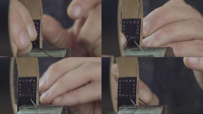 手工制作皮革表带的过程。工匠用针和线缝制皮革表带。手工皮革制品。电影院4k视频。C4k