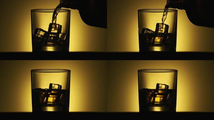 黄色背景下的金色威士忌。用冰倒入玻璃中的酒精