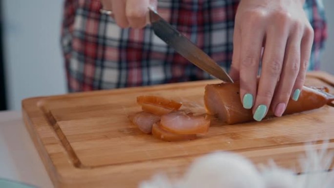 美国妇女在厨房内部的餐桌上切割生涩的肉