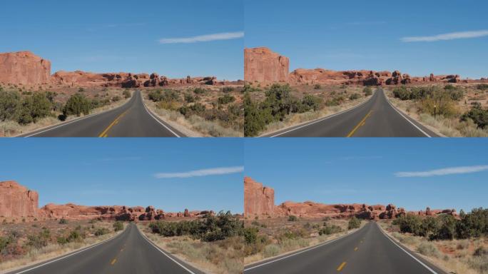 在空旷的道路上行驶，穿过美国沙漠中带有红色岩石地层的拱门公园