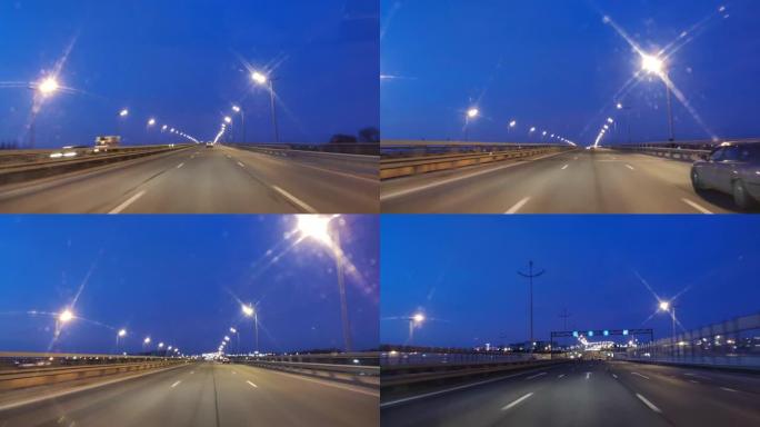 在黑暗视点的高速公路上驾驶汽车的时间推移。超级圈。黄昏日落路灯。晚上，摄像头在前面，挡风玻璃参考。晚