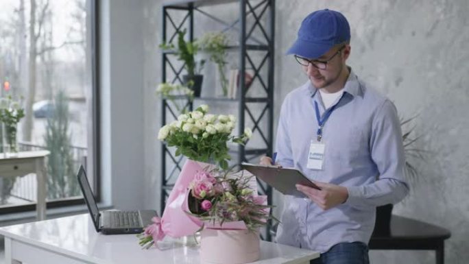 年轻人从在线服务中查看订单清单，以从现代花店中交付新鲜的鲜花花束，成功的概念