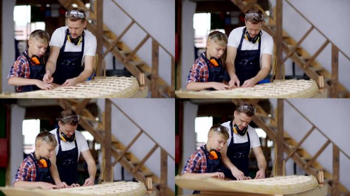 中年木匠和他的小儿子在木工车间一起制作木船模型的侧视图