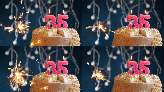 生日蛋糕，蓝色背景上有35个粉色蜡烛和烟火。慢动作和特写视图