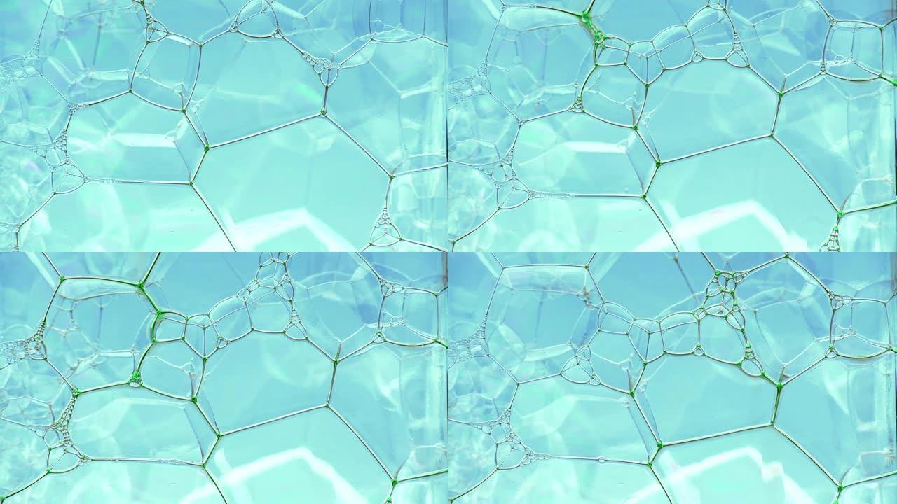彩色肥皂泡沫与爆裂气泡背景。摘要生物结构，大分子模式。绿色墨水填充了大量在液体中形成的蓝色小气泡。自