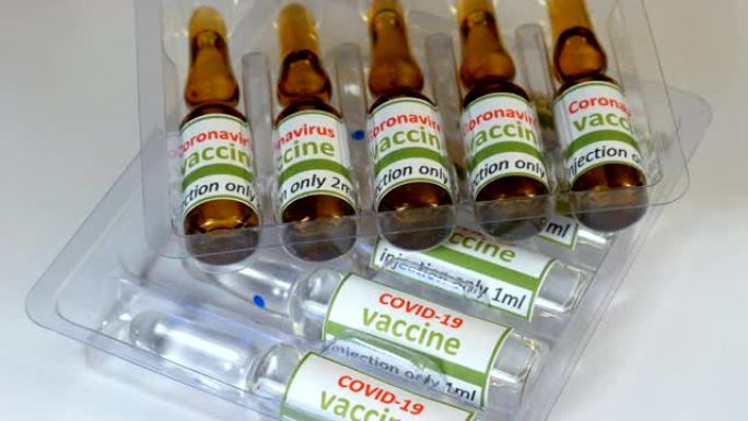 新型冠状病毒肺炎和ncov冠状病毒疫苗、片剂和注射器。实验室，分析一种有色液体，以提取试管中的DNA