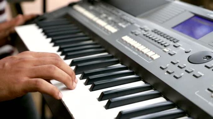 在生锈的钢琴琴键上关闭女钢琴家的手指，arms独奏音乐。男性音乐家演奏的手。