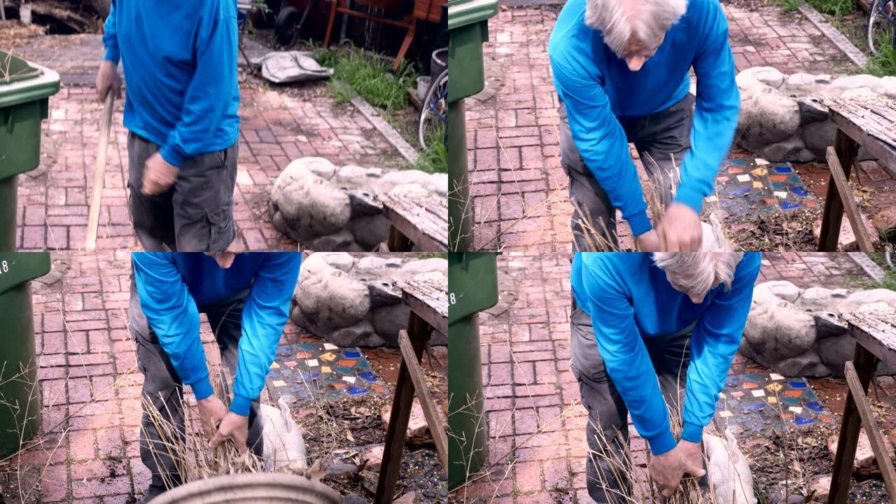 一位退休的老人挣扎着用铁锹将植物从锅中取出
