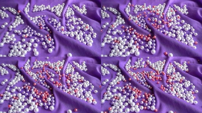 珍珠落在蓝色的布上。慢动作。