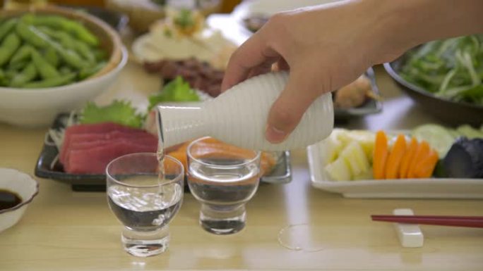 将日本清酒，米酒倒入玻璃杯中