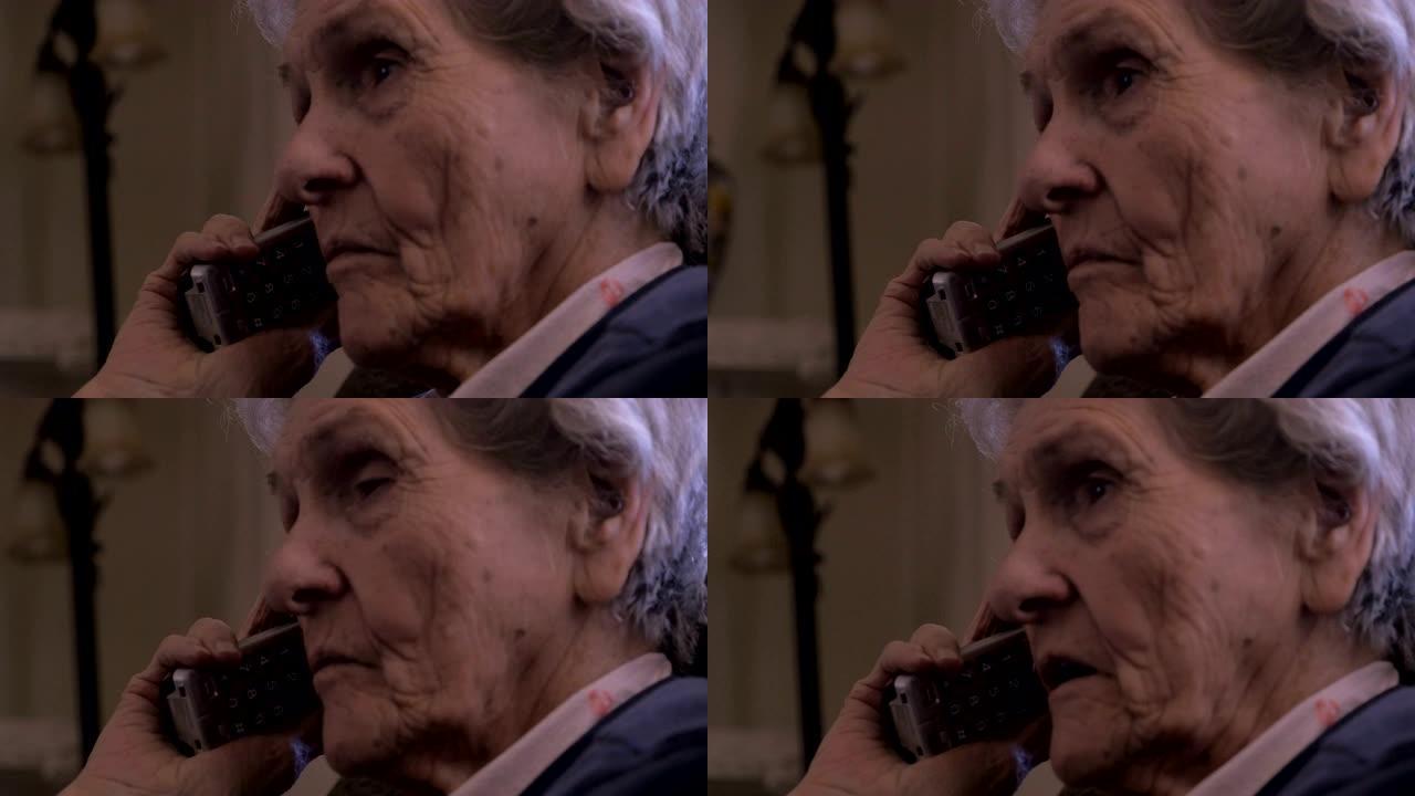 一名90岁的妇女在黑暗的房间里用无绳电话仔细聆听