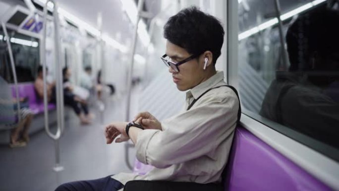亚洲人使用他的智能手表。他正在检查电子邮件，消息或使用移动应用程序