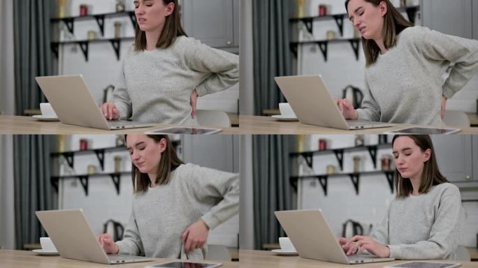 年轻女子在笔记本电脑上工作，背部疼痛