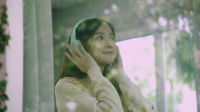 近距离拍摄亚洲年轻女子戴着无线耳机走路打开窗帘呼吸的4k镜头。