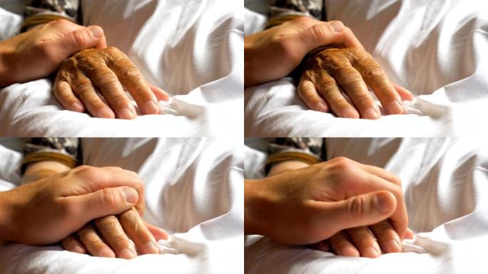 面目全非的人轻轻地抚摸着生病的母亲的手，表现出关心或爱。孙子安慰躺在床上的老奶奶的皱纹手臂。支持他老