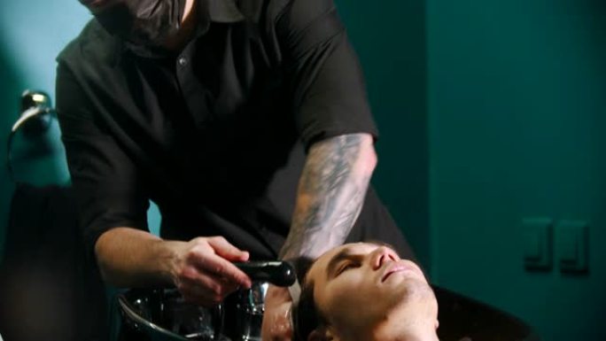 男人理发师洗客户的头发