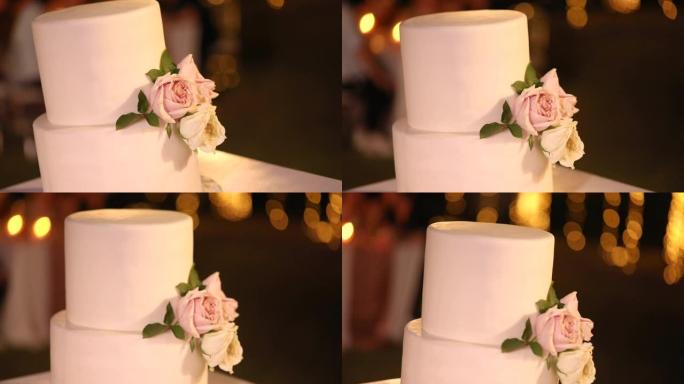 美丽的婚礼蛋糕装饰有鲜花和白色色调。