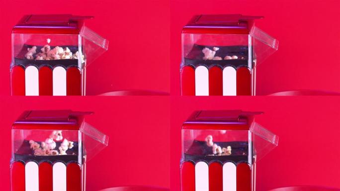 爆米花制造机的特写镜头，红色背景上的热风爆米花爆米花