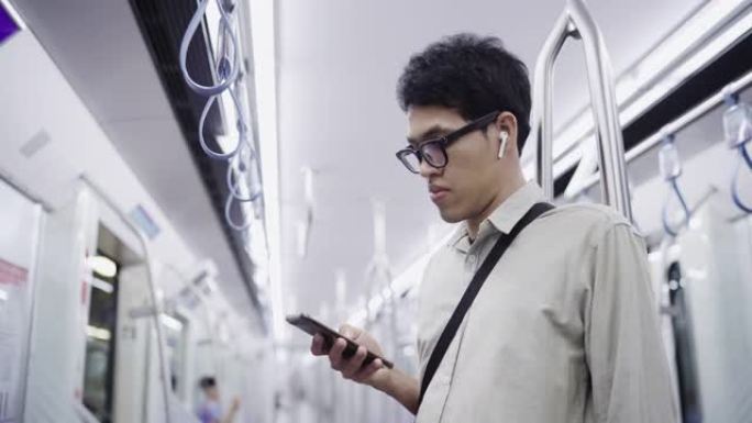 亚洲男子在火车上使用智能手机
