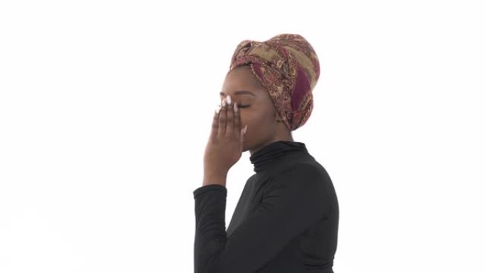 千禧一代的女人闲聊。一位非洲年轻女子窃窃私语并用手遮住嘴的特写肖像。肢体语言