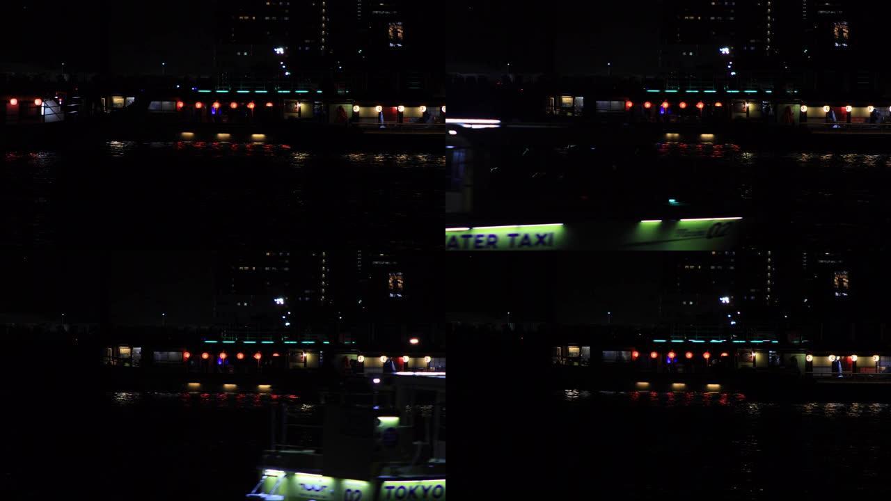 夜间在东京市区的海湾地区移动霓虹灯船
