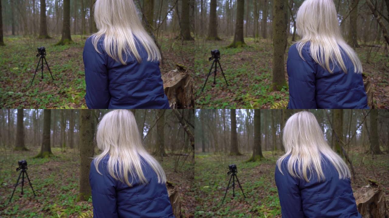 欧洲金发女人写博客是坐在公园森林里的博客。dslr