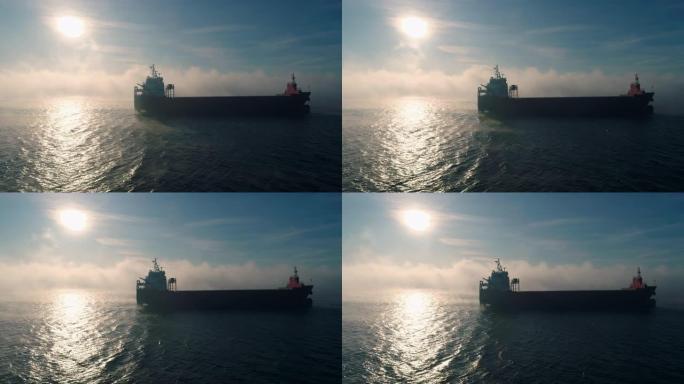 海雾中的货物集装箱船航行的鸟瞰图，为交付集装箱而工作的起重船