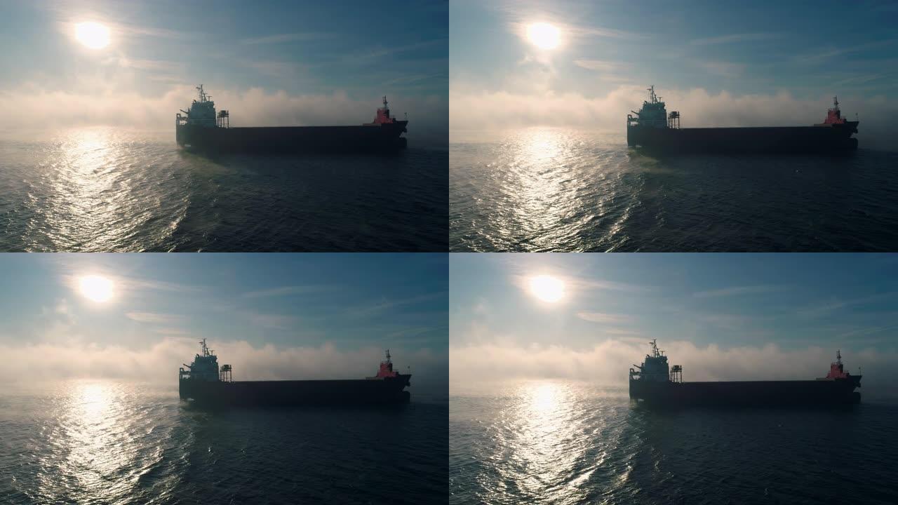 海雾中的货物集装箱船航行的鸟瞰图，为交付集装箱而工作的起重船