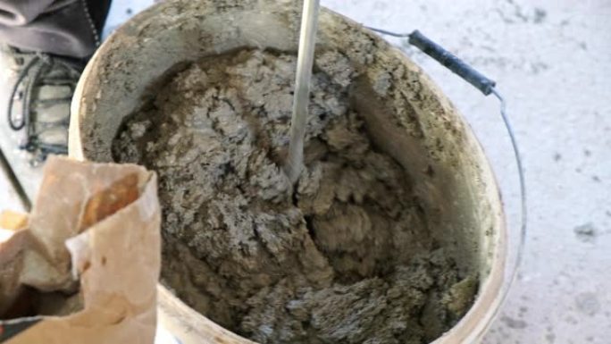 瓦工在桶中搅拌水泥