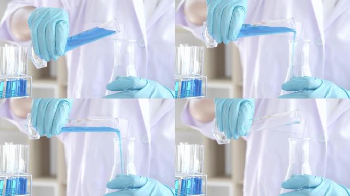 实验室工作的科学家或医学人员的4k视频录像，用于在临床实验室工作的玻璃设备上混合滴落彩色液体试剂的研
