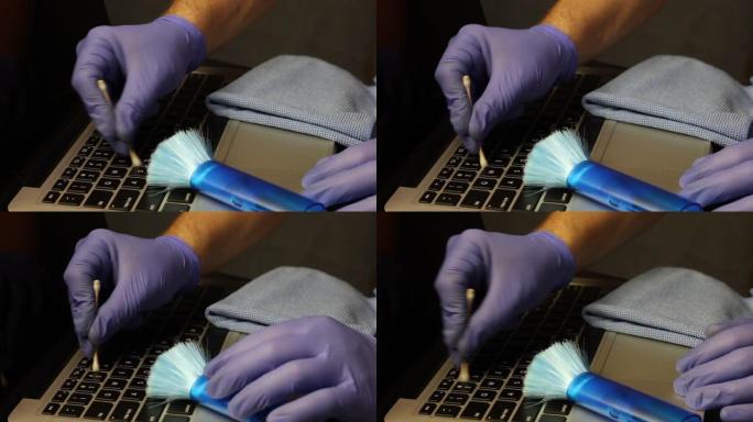 一名戴着橡胶手套的男子用棉签清洁按键之间的笔记本电脑键盘。笔记本电脑的清洁和维护。保护工作设备免受病