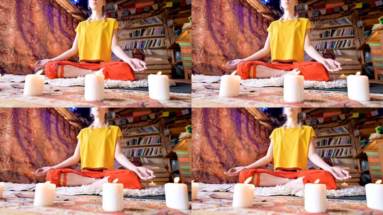 一个穿着宽松衣服的美丽年轻女孩坐在一个工艺房间里，穿着白色皮草皮，荷花姿势被蜡烛包围。冥想精神成长和