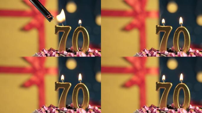 生日蛋糕70号点火器燃烧的金色蜡烛，蓝色背景礼物黄色盒子用红丝带绑起来。特写和慢动作