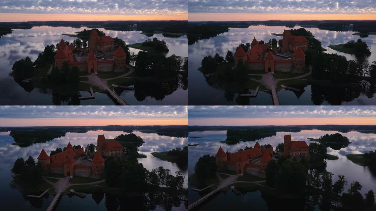 日落时分，立陶宛加尔夫湖的特拉凯岛城堡，戏剧性的天空在水中反射。
