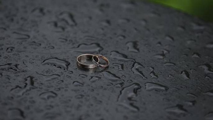 水滴湿表面美丽的金色结婚戒指