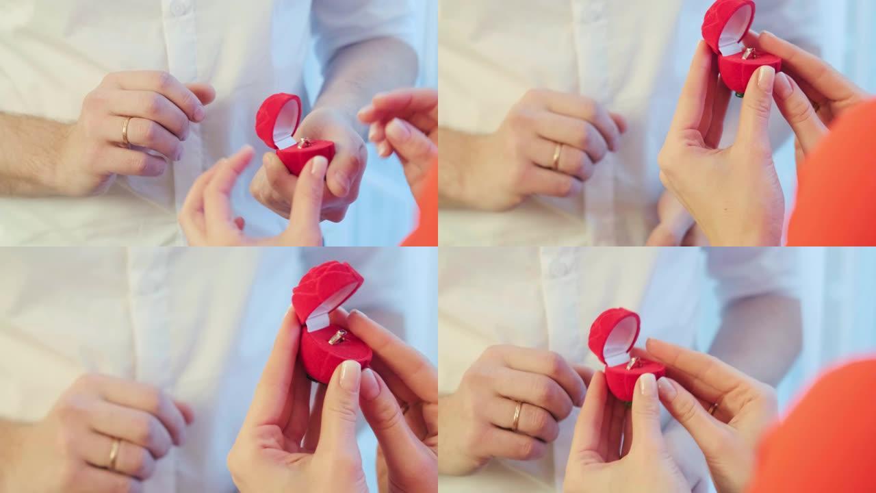 双手合拢。男人给女人一个红色盒子的戒指。女人拒绝男人结婚的提议，给戒指-爱情，情人节和婚礼概念。慢动