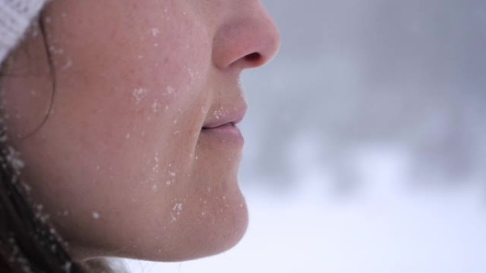 冬季旅行者。一位年轻女性游客的慢动作，在深雪中享受外面的降雪。在冬天的山上玩得开心。肖像。