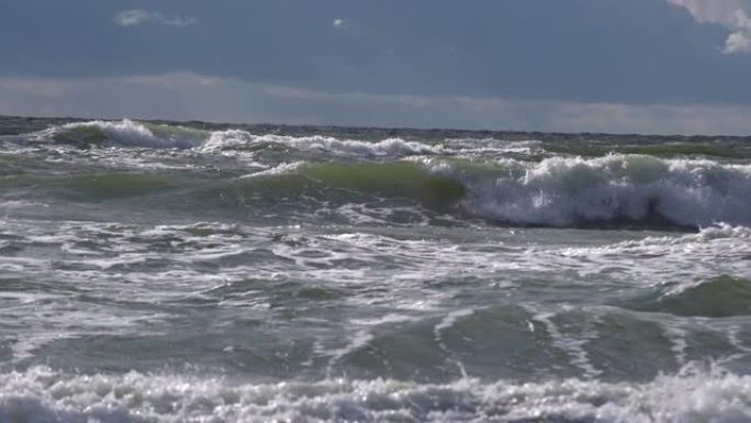 在海里破浪。泡沫在海滩附近坠落的危险海浪，即将来临的潮汐