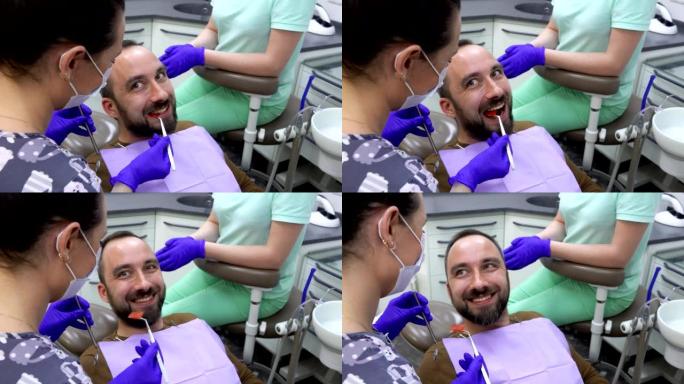 男性患者正在咀嚼特殊的牙科指示器，牙医正在检查它