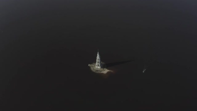 伏尔加河乌格里奇水库被洪水淹没的Kalyazin钟楼的航拍画面。船驶向塔。俄罗斯卡利亚津。无人机上的