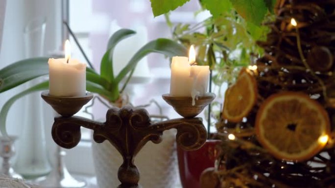 在古董烛台上的两个点燃的白色圣诞节蜡烛的特写镜头。4K