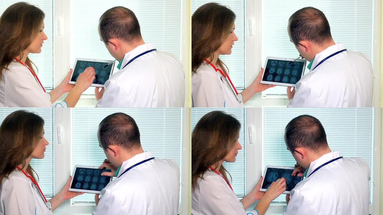 男医生和女医生在平板电脑上分析头部捷运照片