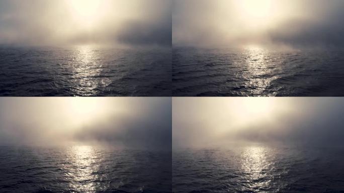海上日出和雾蒙蒙的早晨。蓝色涟漪水面上方的雾，鸟瞰图